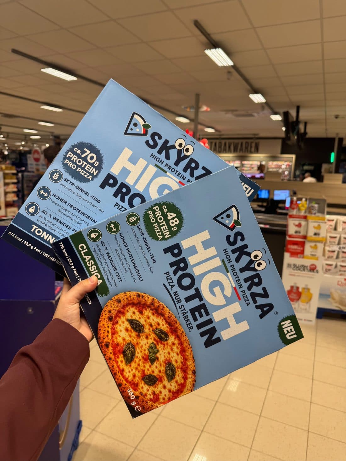 Kundin hält SKYRZA-Packungen im REWE Kreuzau